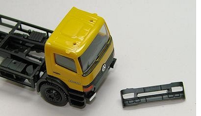 die Stoßstange liegt neben dem Fahrzeug