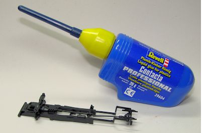 Plastikklebstoffflasche neben den Fahrwerksteilen