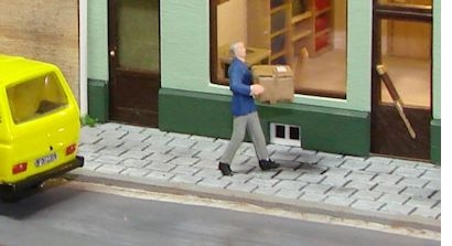 Miniaturpostbote, der ein Paket zustellt