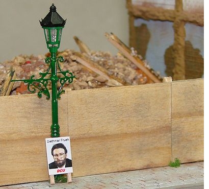 Wahlplakat 'Diethmar Frueh, DCU', welches an einer Laterne befestigt ist