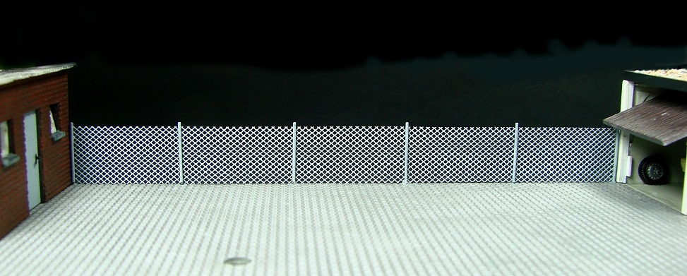 der Maschendrahtzaun verbindet den Schuppen links mit der Garage rechts