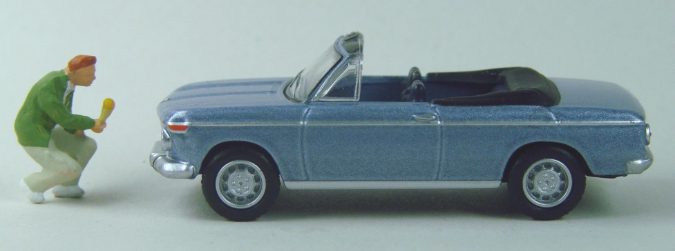 ein Mann hält dem Cabrio eine Einstüte hin